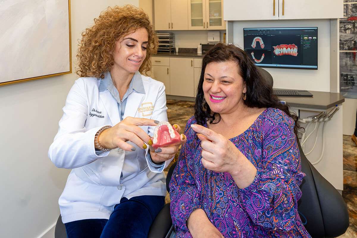 Doctor Showing Patient a Teeth Model
